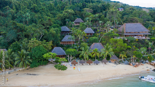 Aerial view of tropical beach with huts surrounded by lush greenery and ocean, Amtrema, Madagascar.