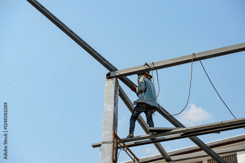 Construction Worker Assembling a Steel Framework the roof of a house Construction Worker Assembling a Steel Framework the roof of a house