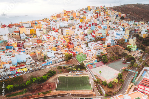 Aerial view of colorful houses and a soccer field on a hillside in the vibrant neighborhood of Barrio de San Jose, Las Palmas de Gran Canaria, Spain. photo