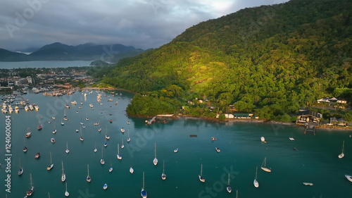 Aerial view of tropical archipelago with serene islands and boats in calm ocean under clouds at sunrise, Angra dos Reis, Brazil. photo