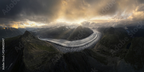 Aerial view of majestic Aletsch Glacier surrounded by rugged mountains under a dramatic sky, Fieschertal, Switzerland. photo