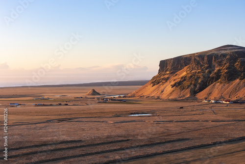 Aerial view of majestic Petursey mountain and rugged coastline at sunset, Vik i Myrdal, Iceland. photo