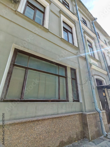 Wallpaper Mural A worn facade of a historic building with rectangular windows and aged plaster. The image captures the character of urban decay and the need for restoration in historic districts. Torontodigital.ca