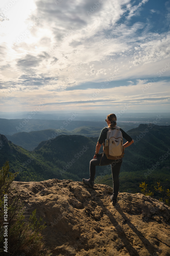 Woman with a backpack on her back on top of a mountain Woman with a backpack on her back on top of a mountain