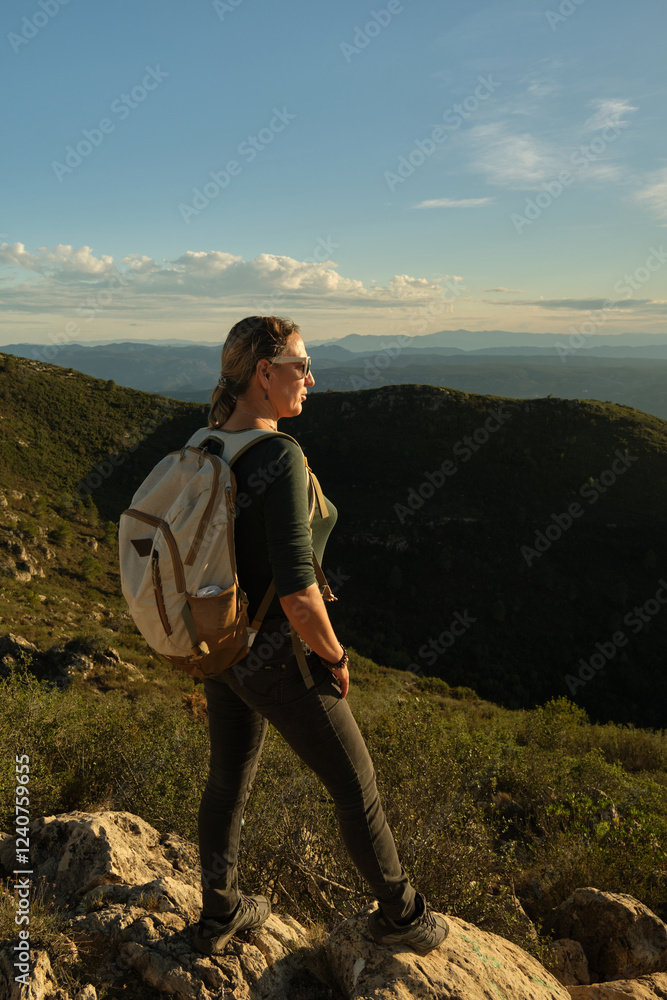 Woman with a backpack on her back on top of a mountain Woman with a backpack on her back on top of a mountain