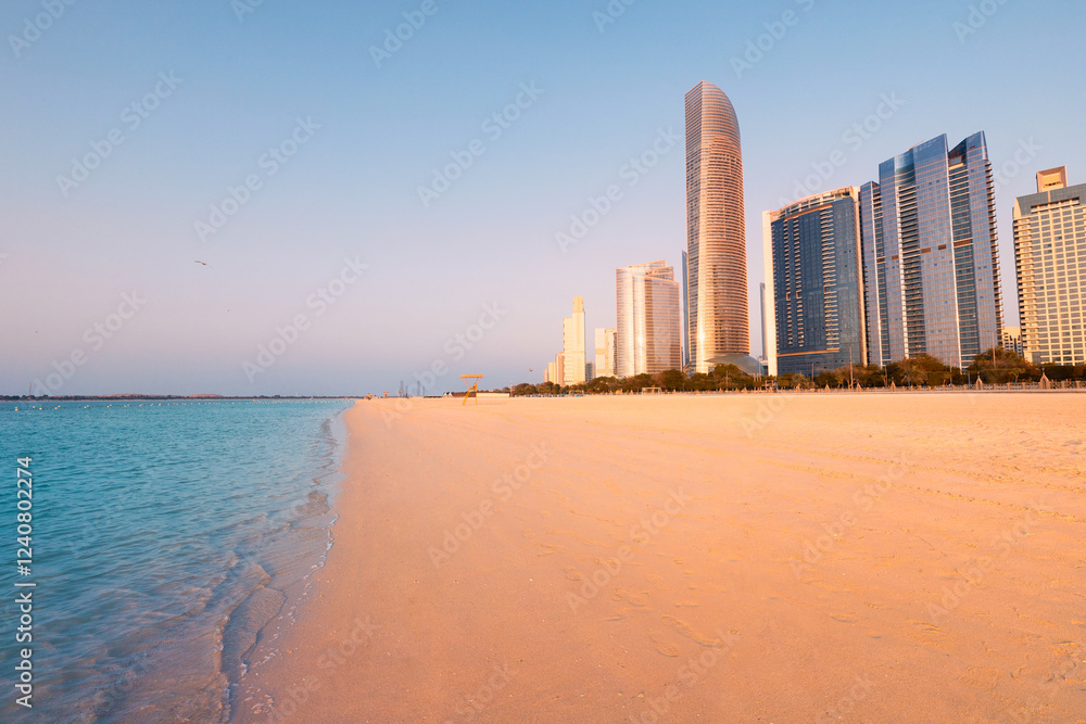 Panoramic view of modern skyscrapers towering over the sandy Corniche beach in Abu Dhabi, UAE, highlighting urban and natural beauty Panoramic view of modern skyscrapers towering over the sandy Corniche beach in Abu Dhabi, UAE, highlighting urban and natural beauty