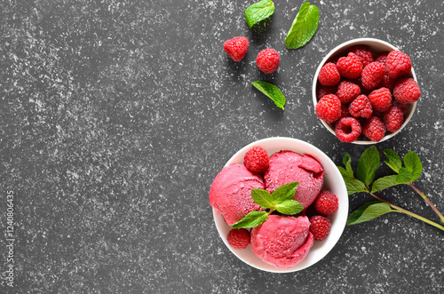 Raspberry ice cream scoop with fresh raspberries and fresh berry in bowl