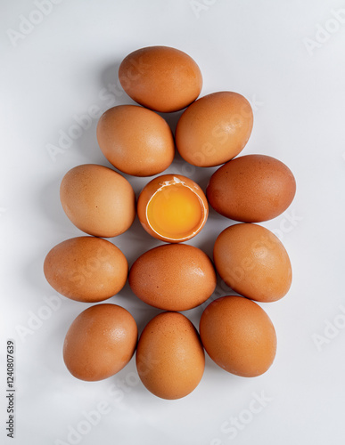 Top view of Egg yolk in Broken raw chicken eggshell in the among of Fresh chicken egg (Hen egg) on white background. Natural organic fresh eggs for healthy food, use it as your Space for text, Design,