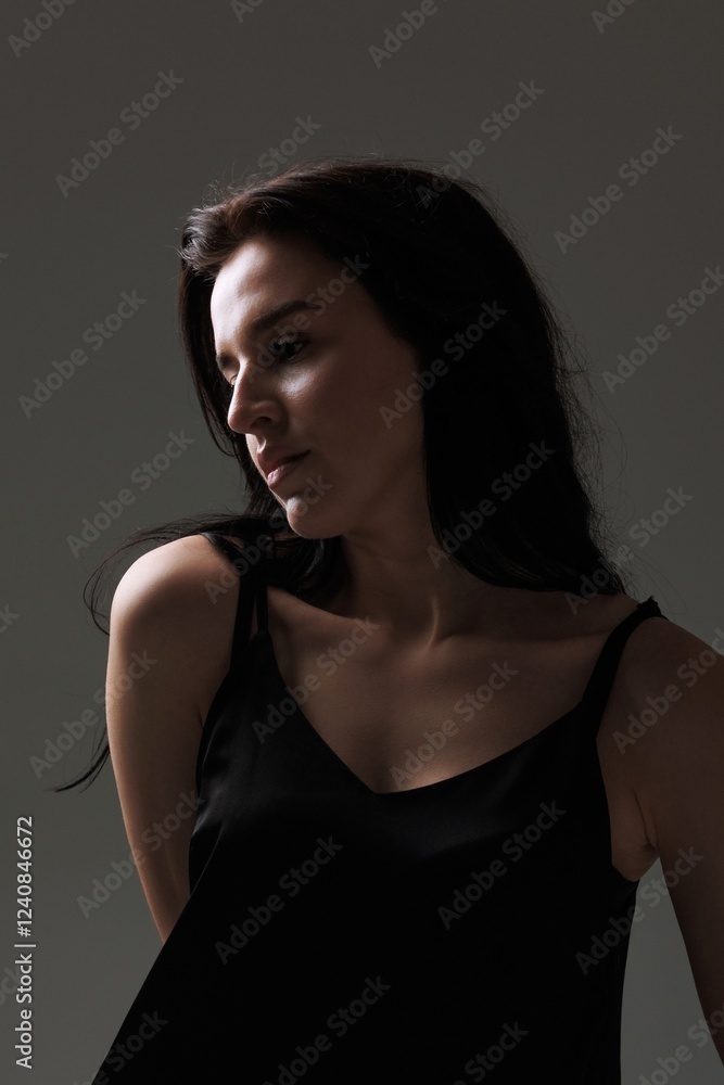 Portrait of a woman with dark hair posing gracefully against a minimalist background Portrait of a woman with dark hair posing gracefully against a minimalist background