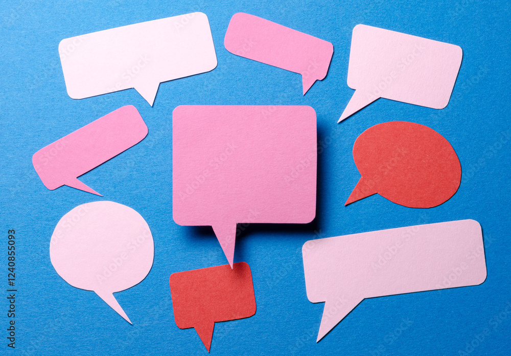 Pink blank cut out paper speech bubbles with copy space for text on blue background, flat lay top view discussion conversation concept Pink blank cut out paper speech bubbles with copy space for text on blue background, flat lay top view discussion conversation concept