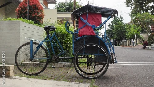 A Blue Becak Parked on a Residential Street