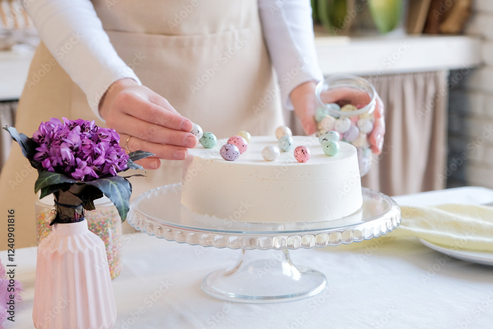 cropped shot of woman decorating Easter cake with sweet eggs in the kitchen cropped shot of woman decorating Easter cake with sweet eggs in the kitchen