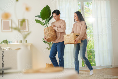 Wallpaper Mural Asian couple carrying woven baskets with a plant and household items, walking through a living space, preparing to settle in their new home. Moving house concept Torontodigital.ca