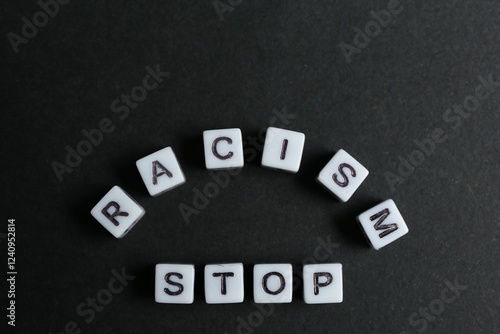 Phrase Stop Racism made with beads on black background, top view photo