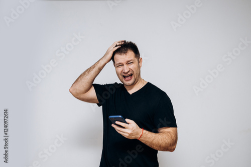 A man in a black t-shirt goofing around and squirming on camera photo