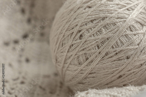 Tableau sur toile A ball of beige knitting yarn lies on a crocheted fabric macro