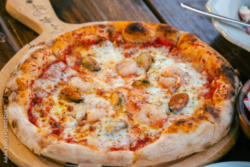  food  from Casa Della Pizza, in Kanchanaburi. The table is set with a delectable spread featuring a crispy, golden pizza topped with fresh a plate of perfectly spaghetti and bowl of  fruit salad