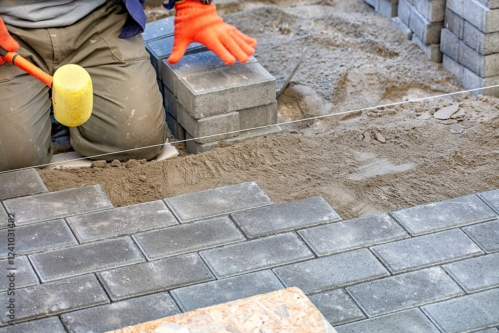 Expert craftsman laying bricks with precision while preparing a walkway in the garden. Copy space.