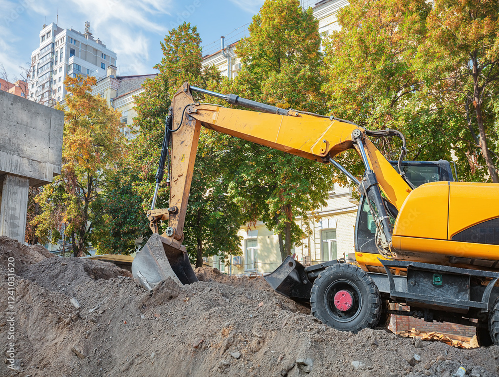 Excavator at work on a sunny day in an urban construction site. Copy space.