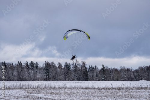 Winter Flight: A Paramotor Above the Snowy Landscape.. Gliding Through the Sky: Paramotor in Action photo