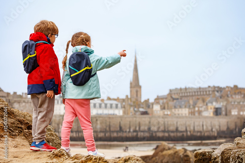 Siblings in jacket enjoy scenic view from the rock point at town