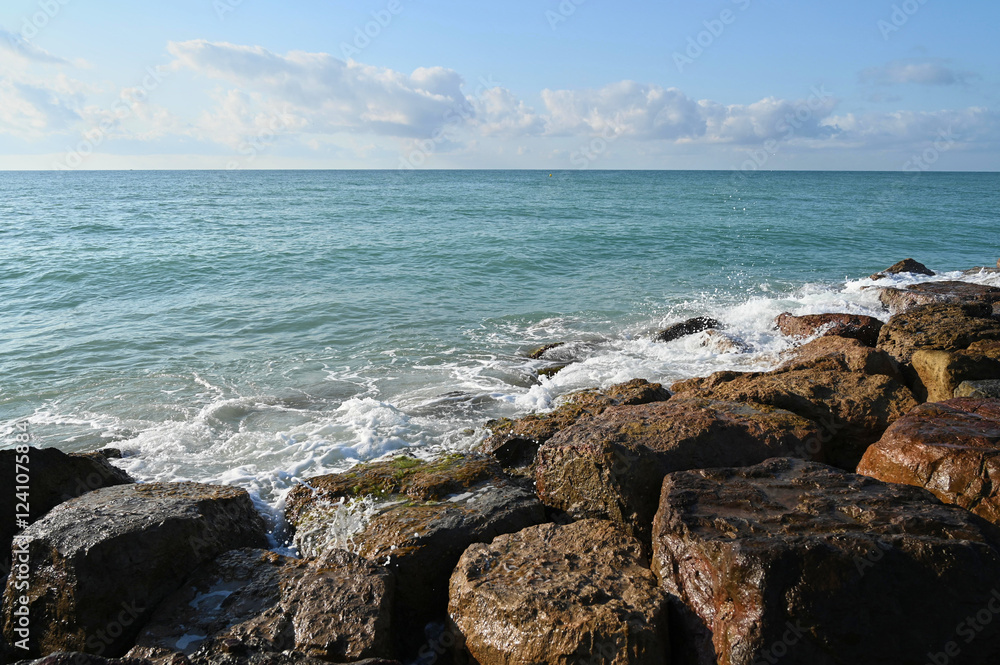 The sun reflects off the calm waters as gentle waves roll in, crashing against weathered stones along the shoreline, creating a peaceful atmosphere by the sea. The sun reflects off the calm waters as gentle waves roll in, crashing against weathered stones along the shoreline, creating a peaceful atmosphere by the sea.