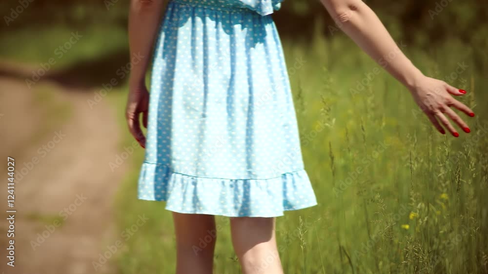 Girl touching flowers and grass while enjoying nature on meadow Girl touching flowers and grass while enjoying nature on meadow