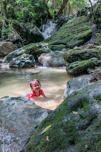 Obraz na płótnie little asian girl playing by the waterfall with a heart full of laughter. w salonie