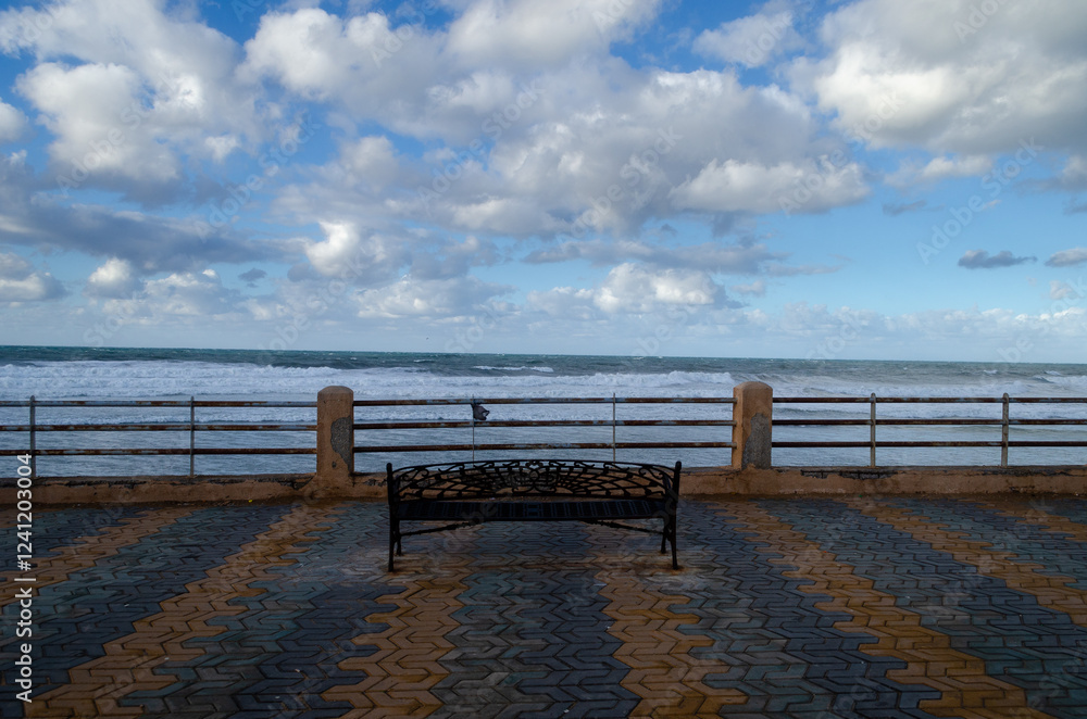 bench facing a sea and a cloudy sky bench facing a sea and a cloudy sky