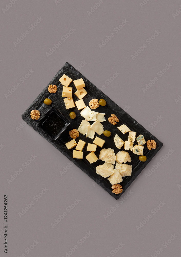 top shot on gray background black stone board with diced cheese assorted cheese plate served with honey nuts and grapes delicacy with wine French traditions top shot on gray background black stone board with diced cheese assorted cheese plate served with honey nuts and grapes delicacy with wine French traditions