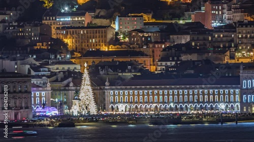 Timelapse of Lisbon's Commerce Square illuminated for Christmas. Tourists gather around the glowing tree and decorations during the opening light show. Iconic night scene in Portugal's capital city