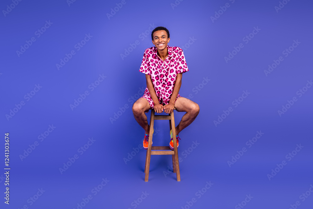Fashionable young man in a leopard print outfit posing stylishly against a vivid purple background Fashionable young man in a leopard print outfit posing stylishly against a vivid purple background