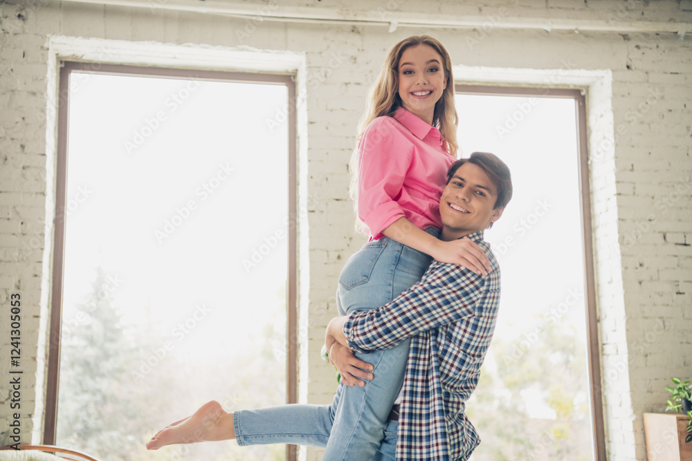 Happy couple enjoying time together inside a bright and cozy living room during the daytime Happy couple enjoying time together inside a bright and cozy living room during the daytime