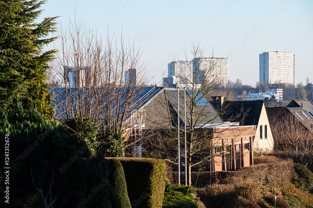 High angle view over residential houses in Wemmel (Flanders) with high rise apartment blocks in the background in Brussels, Belgium High angle view over residential houses in Wemmel (Flanders) with high rise apartment blocks in the background in Brussels, Belgium