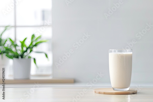 glass of milk on wooden coaster in bright kitchen