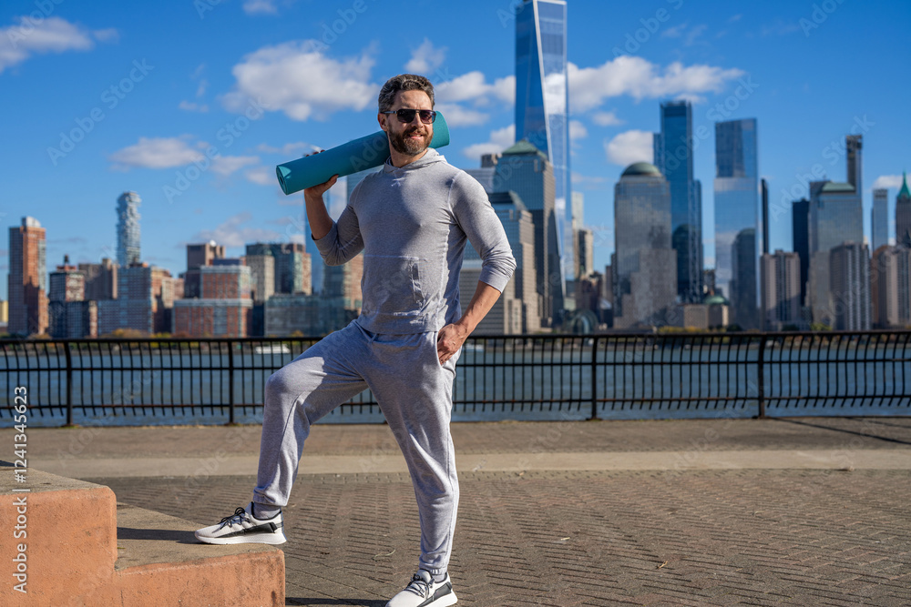 Sportsman in New York. Man in sportswear with fitness mat in Manhattan. Fit your body. Yoga coach. Sport man ready for workout. Healthy lifestyle. Fitness and sport. Yoga mat for training. Sunny day Sportsman in New York. Man in sportswear with fitness mat in Manhattan. Fit your body. Yoga coach. Sport man ready for workout. Healthy lifestyle. Fitness and sport. Yoga mat for training. Sunny day