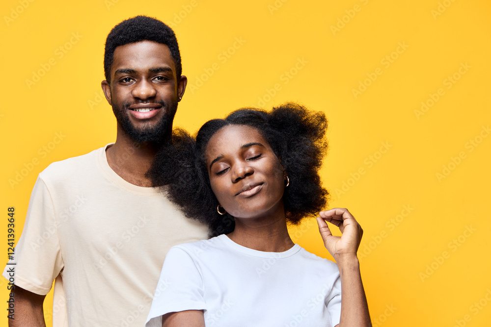 Obraz premium African couple with joyful expressions against a bright yellow background, showcasing love and confidence through their vibrant colors and relaxed outfits