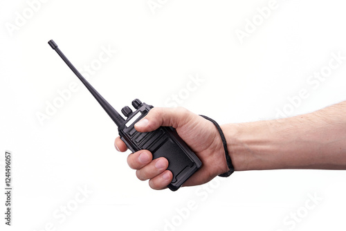 A black walkie-talkie is held in the hand on a white background.