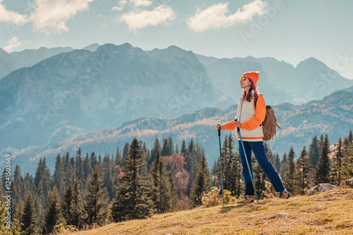 Obraz na płótnie Female hiker standing on a grassy hill and enjoying a mountain view in Durmitor National Park, Montenegro w salonie