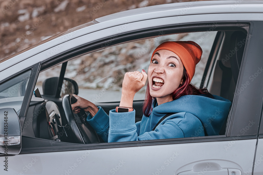 Angry female driver shaking fist at another car while driving