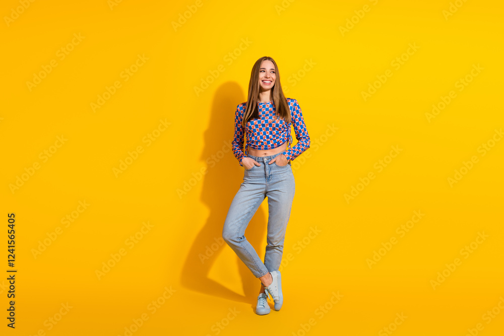 Stylish young woman in patterned top against vibrant yellow background showcasing casual fashion Stylish young woman in patterned top against vibrant yellow background showcasing casual fashion