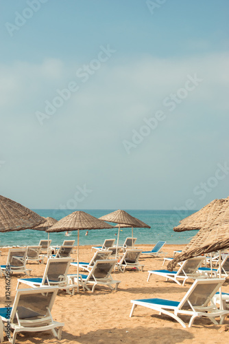 Empty deck chairs on the sandy beach by the beautiful sea