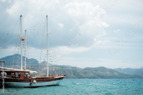 A cove with a yacht. A boat trip. Luxury yacht rentals. The marina. Luxury yachts in summer. Sea yacht in the port. Magnificent view of the mountains.