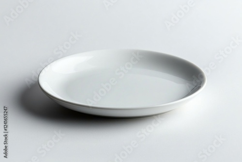 A white ceramic plate on a clean white background exudes minimalist design and tranquility