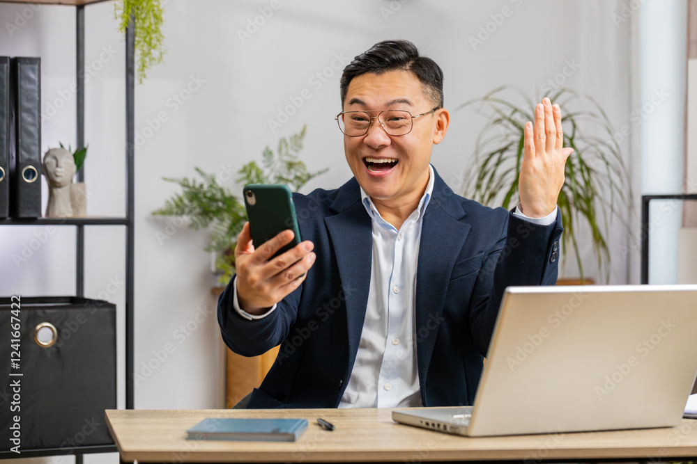 Happy Chinese businessman freelancer use mobile smartphone celebrating success victory winning lottery jackpot goal achievement, play game, good positive news, triumph working at home office workplace Happy Chinese businessman freelancer use mobile smartphone celebrating success victory winning lottery jackpot goal achievement, play game, good positive news, triumph working at home office workplace