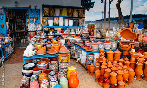 Shelves filled with handcrafted Moroccan pottery, including tagines, painted vases, and clay pots.