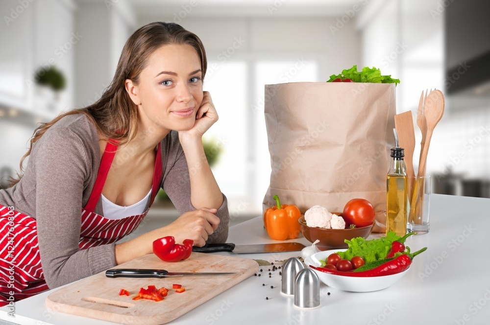 Shot of beautiful young woman cooking food in kitchen Shot of beautiful young woman cooking food in kitchen