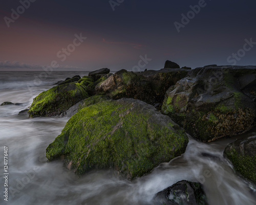 USA, New Jersey, Cape May National Seashore. Sunrise on ocean shore and rocks.