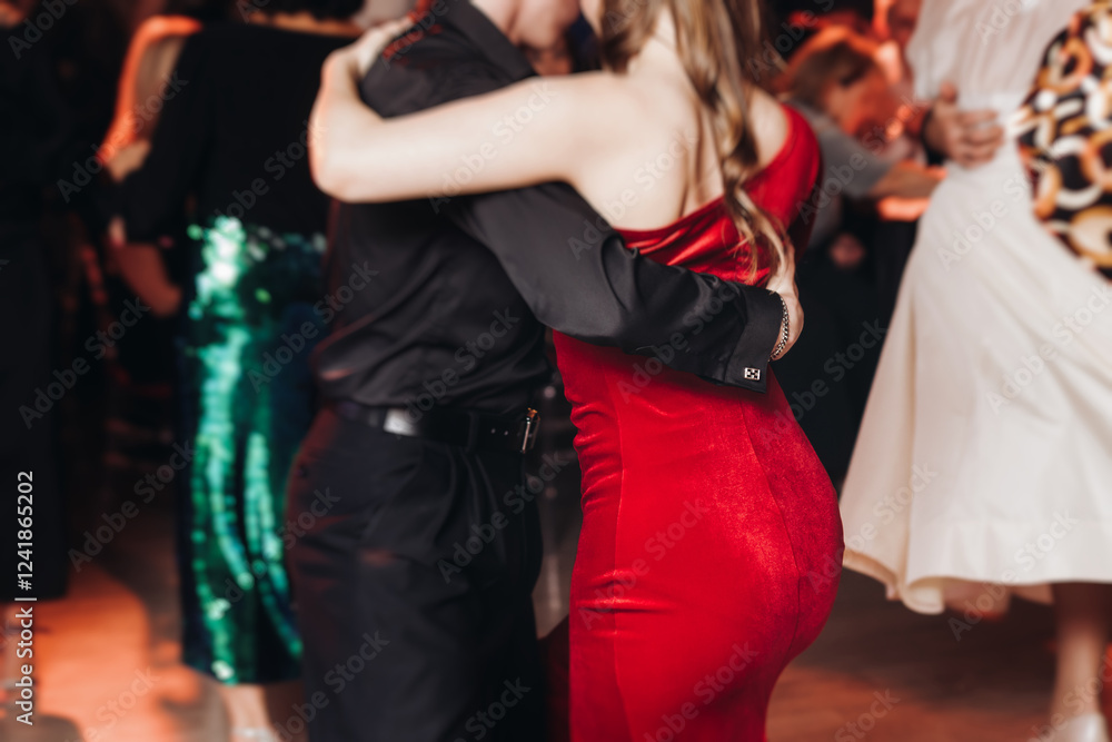 Naklejka premium Couples dancing traditional latin argentinian dance milonga in the ballroom, tango salsa bachata kizomba lesson in red and purple lights, performance rehearsal, evening dance school class festival