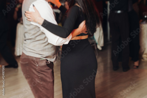 Couples dancing traditional latin argentinian dance milonga in the ballroom, tango salsa bachata kizomba lesson in red and purple lights, performance rehearsal, evening dance school class festival photo